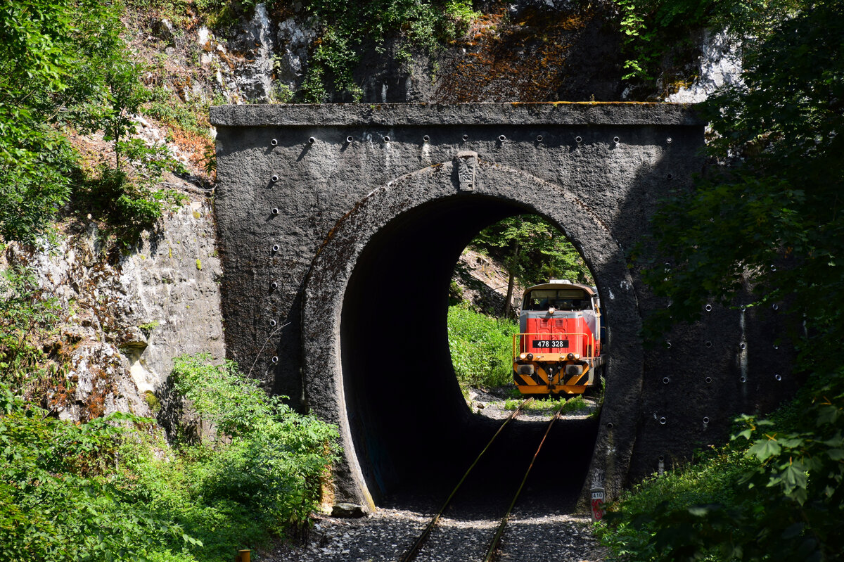 Die Verschublok 478 328 mit dem Personenzug von Veszprém nach Győr auf der Bakonybahn bei der Tunneleinfahrt kurz vor Vinye. 24.07.2021.