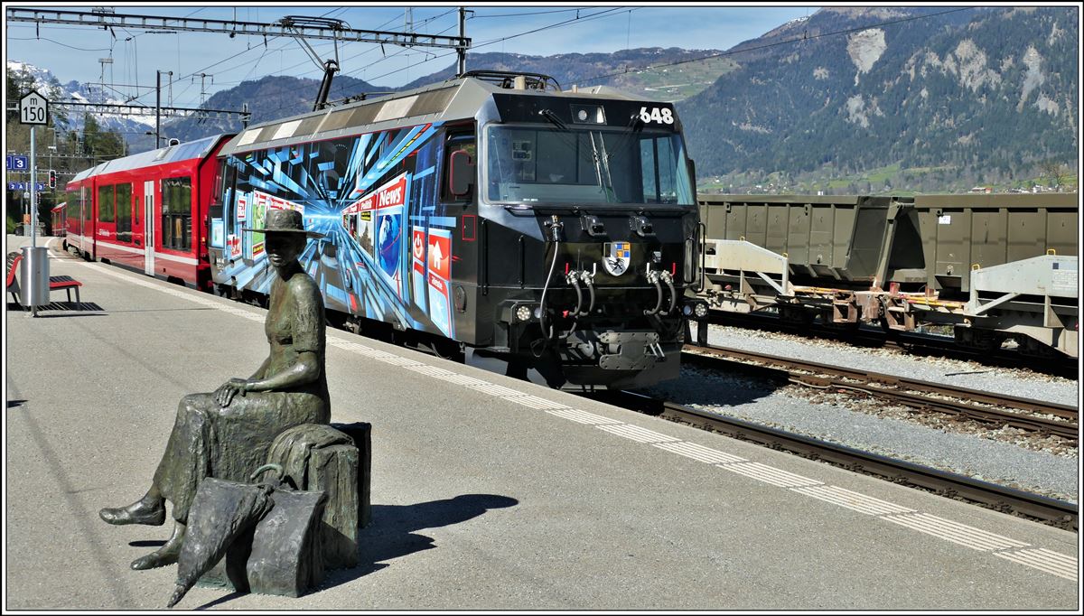 Die Wartende von Bildhauer Robert Indermaur mit IR1149 nach St.Moritz gezogen von  der Ge 4/4 III 648  Susch  in Thusis. (15.04.2020)