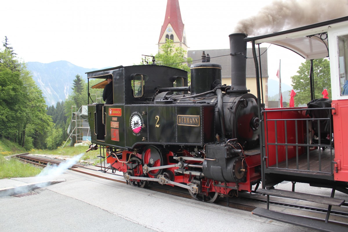 Die Zahnradlokomotive  Hermann  mit einem Personenwaggon auf der Fahrt zum Bahnhof Jenbach, hier bei Km 3,6 bei der Haltestelle Eben, Mai2014