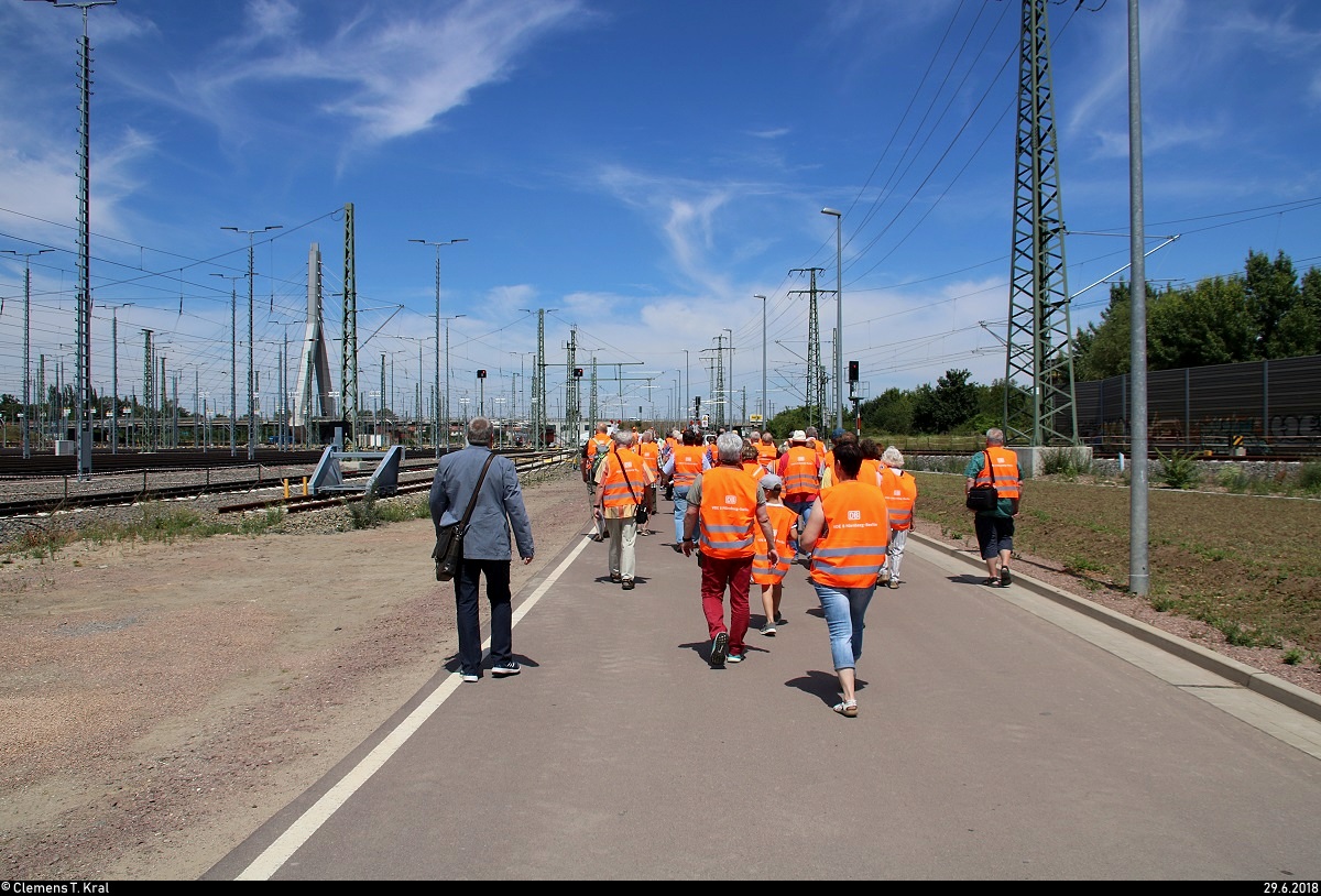 Die Zugbildungsanlage (ZBA) Halle (Saale) wurde im Rahmen des Verkehrsprojekts Deutsche Einheit Nr. 8 (VDE 8) nach fast fünf Jahren Bauzeit auf dem Gebiet des alten Rangierbahnhofs feierlich eingeweiht. Alle Interessierten waren neben den Feierlichkeiten von der Deutschen Bahn dazu eingeladen, an einer Rundfahrt über die Anlage teilzunehmen.
Auf diesem Bild macht sich die erste Gruppe - ausgestattet mit Warnwesten - auf dem Weg zum Dieseltriebwagen.
Der Standort war für diesen Tag also zugänglich.
Weitere Informationen findet Ihr hier:
https://bahnblogstelle.net/2018/06/29/neue-zugbildungsanlage-in-halle-saale-geht-in-betrieb-2/
https://www.youtube.com/watch?v=MjjKnF1WnSQ
[29.6.2018 | 13:48 Uhr]