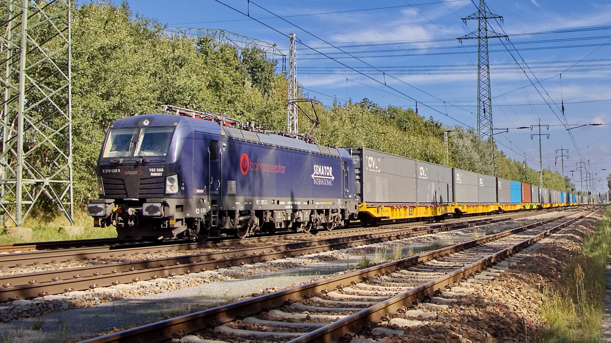 Diedersdorf am 28. September 2023 auf dem südlichen Berliner Ring fährt Industrial Division Sp. z o.o., Wrocław [PL] mit  5 370 038-9/193 568  mit dem Namen:  Robert  (NVR-Nummer: 91 51 5370 038-9 PL-ID) und einem Ganzzug Containertragwagen.