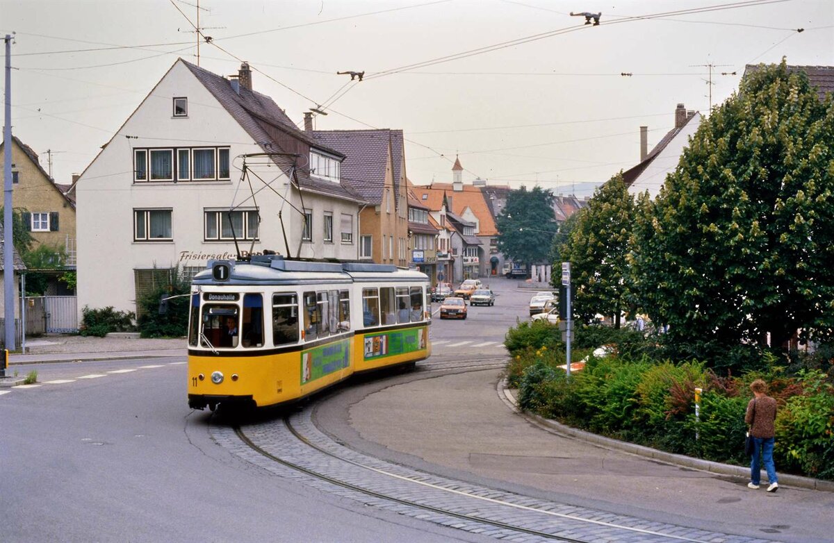 Dies ist die enge Wendeschleife der Ulmer Straßenbahn in Söflingen. Ein Wagen der Baureihe GT4 (MF Esslingen), TW 11, durchfährt sie mutig. Das Foto entstand am 29.09.1984.