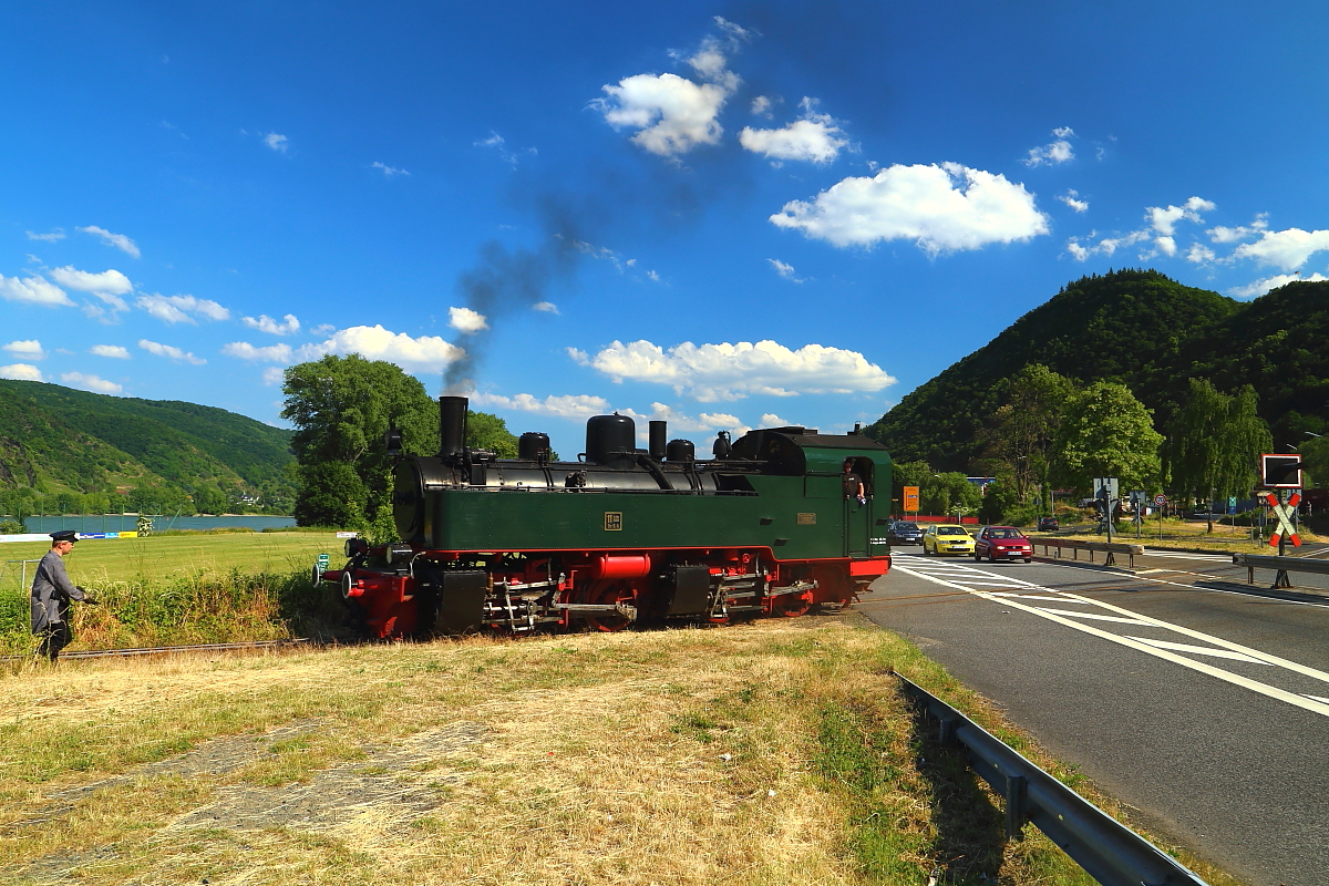 Dies ist nunmehr mein letztes Bild von der Sonderzugveranstaltung am 05.06.2015, anläßlich der Wiederindienststellung von Mallet 11sm. Das Bild zeigt genannte Lok kurz nach dem Überqueren der B 9 in Brohl-Lützing auf dem Weg zum Hafen, wo drei Regelspurwaggons abgeholt und danach zum Brohler Güterbahnhof gebracht werden. Leider konnte ich davon kein Bild mehr machen. Da ich bereits den ganzen Tag bei Temperaturen von weit über 30°C und praller Sonne im Freien unterwegs war und leichtsinnigerweise den Sonnenschutz vergaß, hatte mein Haut bereits die Farbe eines gerade in den Kochtopf geworfenen Hummers angenommen, sodaß ich es vorzog, die Heimreise anzutreten! ;-)
Bleibt mir nur noch, mich bei der IG Brohltal-Schmalspureisenbahngesellschaft e.V. als Organisator dieser tollen Veranstaltung zu bedanken. Ebenso beim Lok- und Zugpersonal, welche bei den herrschenden Temperaturen und dem großen Menschenandrang nahezu Unmenschliches leisteten, um diese Veranstaltung zu einem Erfolg werden zu lassen. Und das ist ihnen vollauf gelungen!