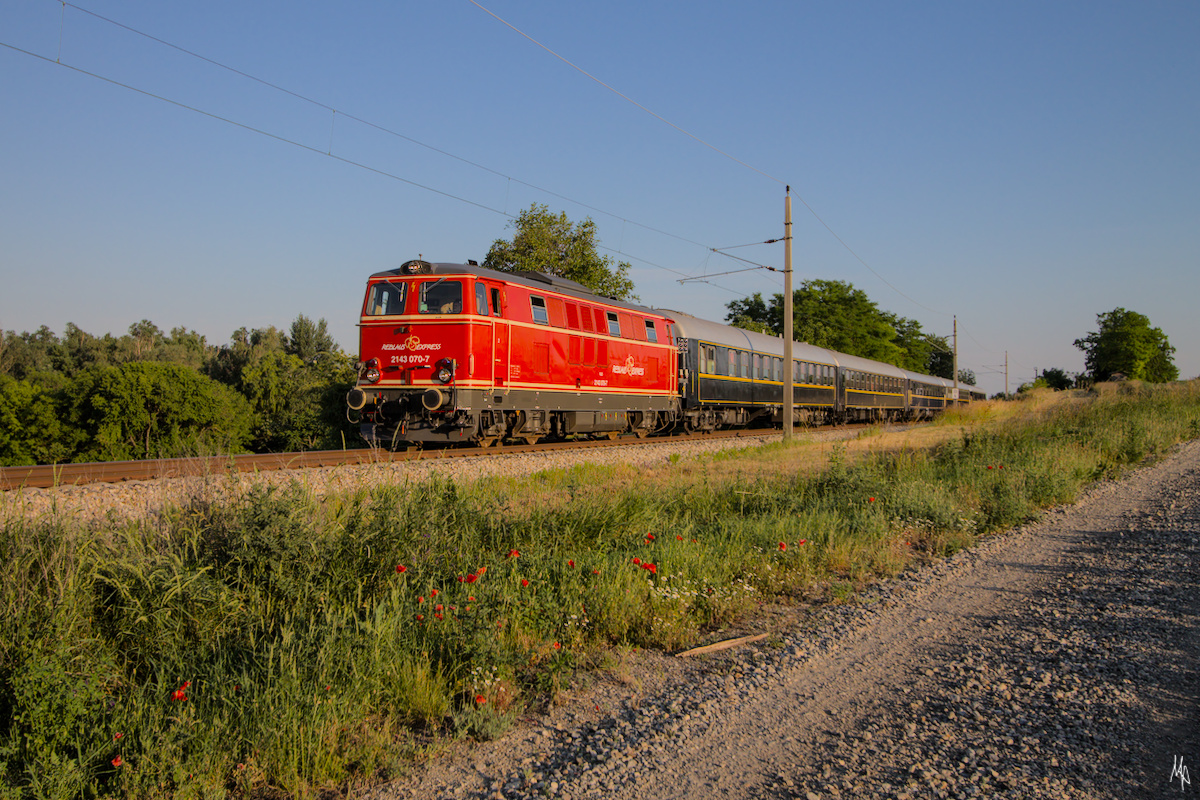 Diese Aufnahme verdanke ich einen Zufall, da ich von dem Zug nichts wusste. Ich war entlang der S2-Strecke Wien-Mistelbach mit dem Fahrrad unterwegs, um mögliche Fotopunkte zu suchen, als ich einen anderen Eisenbahnfotografen traf. Plötzlich ließ sich das Fahrrad nicht mehr weiter bewegen, sodass ich ebenfalls auf den Zug warten musste.
Die 2143.070 der Neuen Landesbahn ist mit Wagen des Majestic Imperator nach Mistelbach unterwegs, wo diese Wagen am darauf folgenden Tag für Sonderzug zur Sonnwendfeier in der Wachau benötigt wurden. (18.06.2021)