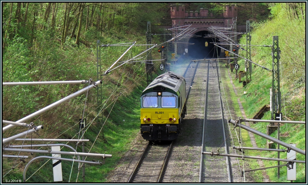 Diese Class 66 aus Belgien kommend,verlässt gerade den Gemmenicher Tunnel und fährt downtown nach Aachen West. Bildlich festgehalten unweit von Aachen an der Montzenroute im April 2014.