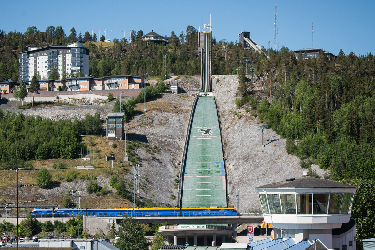 Diese Situation dürfte wohl weltweit einzigartig sein: Der Bahnhof Örnsköldsvik überspannt im nördlichen Bahnsteigbereich über eine Brücke den Auslauf einer Skisprungschanze. 11.06.2018