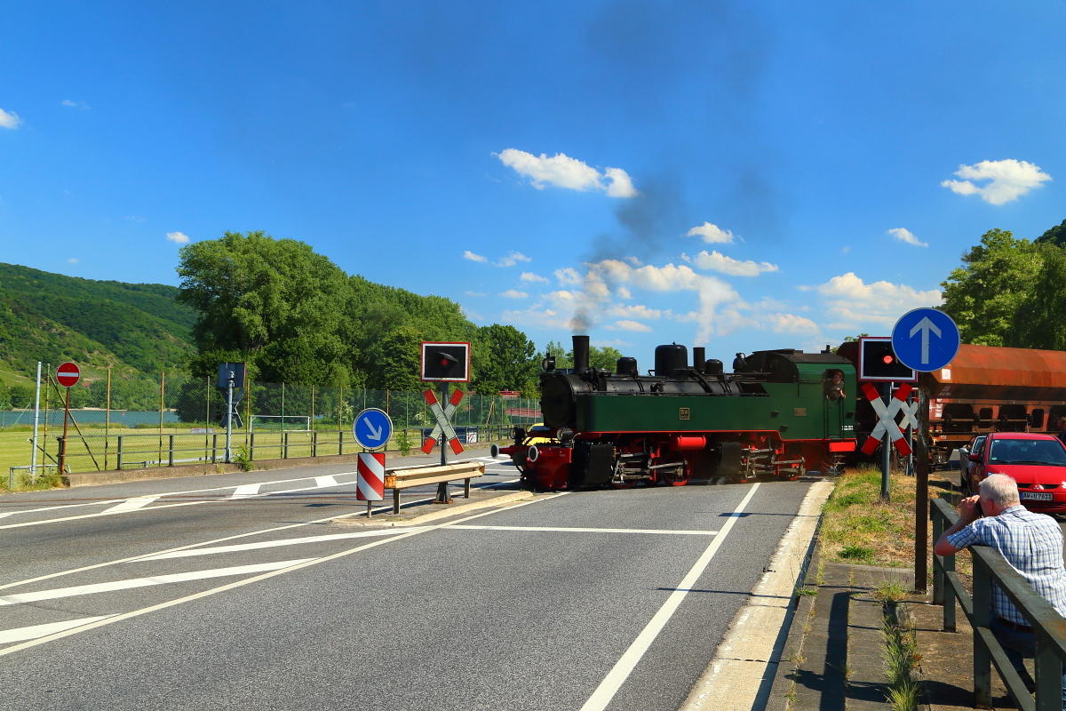 Diese Szene gab es seit 1966 nicht mehr und stellt somit eine absolute Premiere dar! Die kürzlich wiederindienstgestellte Meterspur-Mallet 11sm der Brohltalbahn überquert auf dem Dreischienengleis, am Nachmittag des 05.06.2015 im Rahmen einer Fotoveranstaltung, mit einer regelspurigen Rangiereinheit, auf dem Weg vom Brohler Güterbahnhof zum Hafen, gerade die B 9 (Koblenzer Straße) in Brohl-Lützing. (Bild 1)