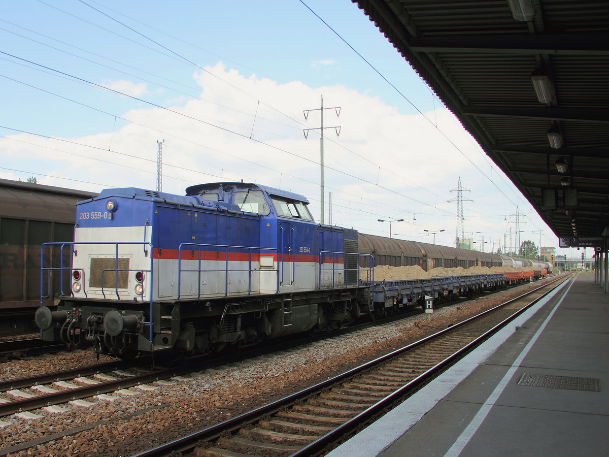 Diesellok 203 559-0 (92 80 1203 164-9 D- LOCON) als LOCON 219 mit Drehgestell-Flachwagen bei der Durchfahrt durch den Bahnhof Berlin Schönefeld Flughafen am 23. Juli 2014.