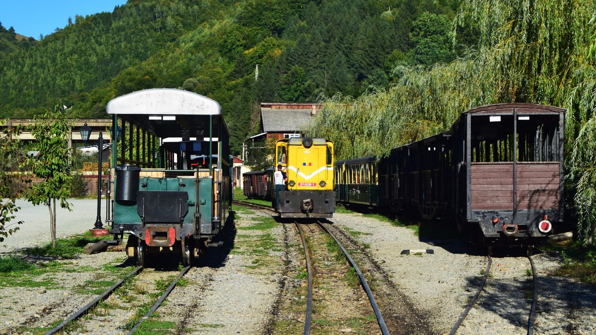 Diesellok 87-0036-1 manöviert am 14.09.2017 zwischen abgestellten historischen Personenwwagen in der Endstation der Wassertalbahn, in Viseu de sus.
