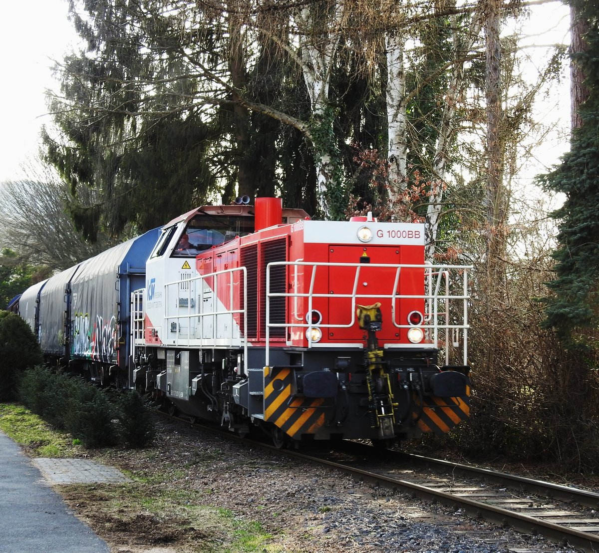 DIESELLOK VOSSLOH G 1000 BB der KSW IN NEUNKIRCHEN/SIEGERLAND
Die bildschöne rot-weiße Diesellok VOSSLOH G 1000 BB der KREISBAHN SIEGEN-
WITTGENSTEIN konnte ich mit Güterwagen am 21.3.2018 auf der Fahrt von HERDORF
nach SALCHENDORF(Schäfer-Werke) durch den  Ortskern von NEUNKIRCHEN
fotografieren,direkt vorbei an den Gärten der Wohnhäuser.....