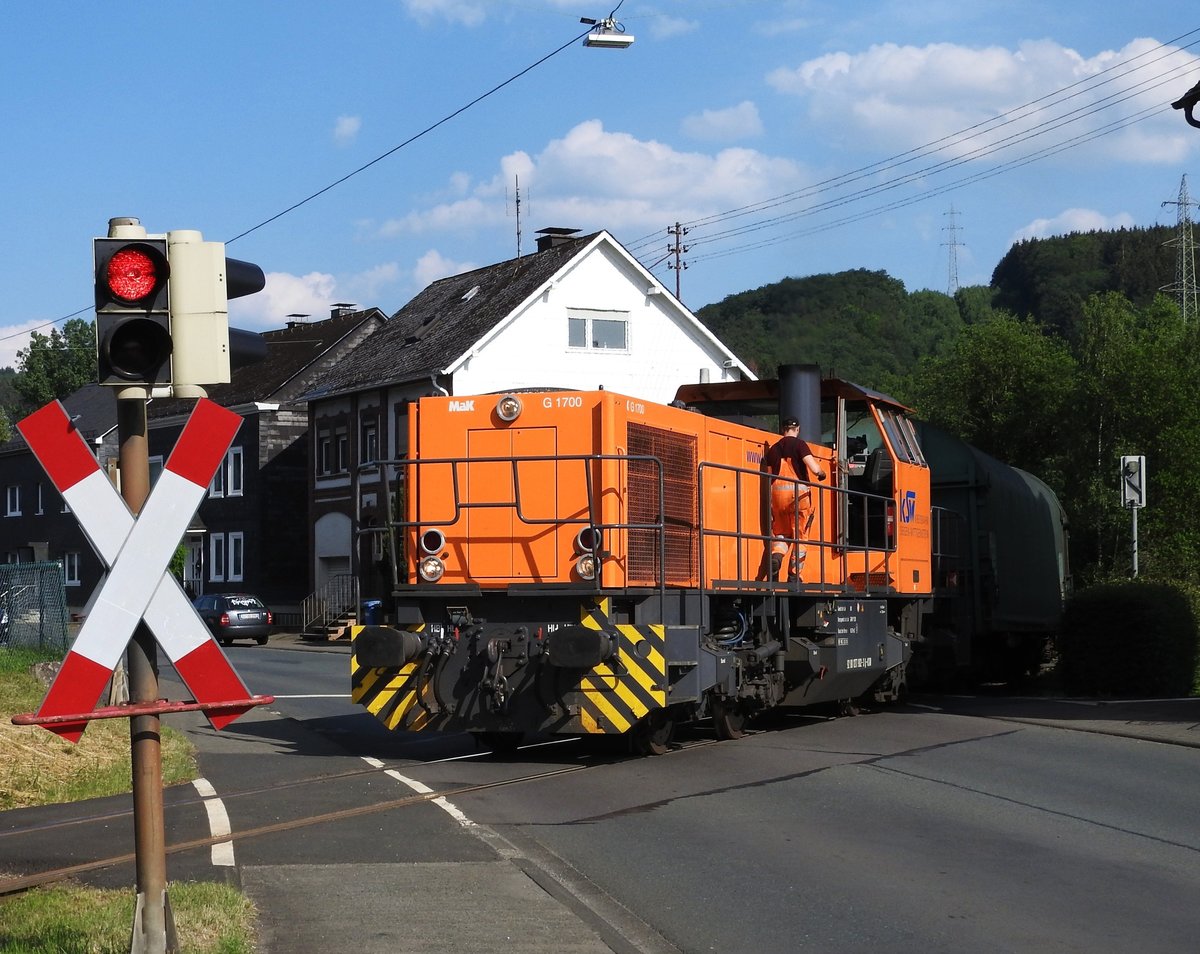 DIESELLOK VOSSLOH MAK G 1700 BEI ORTSDURCHFAHRT SALCHENDORF/SIEGERLAND
Am Spätnachmittag des 6.6.2018 befindet sich VOSSLOH MAK G 1700 mit 5
angehängten (Leer)Güterwagen auf der Fahrt vom BAHNHOF HERDORF zum SCHÄFER/SSI-
Zweigwerk PFANNENBERG in der Ortsmitte von SALCHENDORF,der Heimat der
Weltfirma SCHÄFER/SSI...-hatte eigentlich auf die neuere Vossloh G 1000 BB
gewartet,die hätte noch einige Waggons mehr für die Steigungsstrecke am Haken
gehabt....Der Lokbegleiter hatte gerade am Schaltkasten die Warnblinkanlage
für die Straße SALCHENDORF-WILNSDORF eingeschaltet und befindet sich auf dem Weg zurück in den Führerstand der Lok.......
