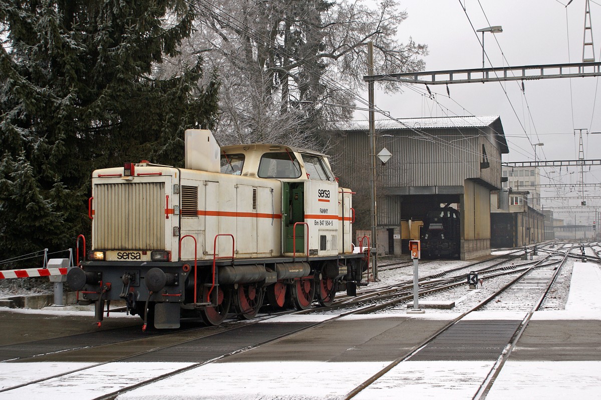 Diesellokomotiven im Dienste der Stahl Gerlafingen: Die eingemietete Bm 847 954-5  FANNY  von Sersa anlässlich einer Pause vor dem Lokschuppen des Stahlwerks Gerlafingen am 20. Januar 2010. Die schwarze MRCE-Dispolok watete zur Zeit der Aufnahme in der Remise auf ihren nächsten Einsatz.
Die Aufnahme ist vom Bahnsteig aus entstanden.
Foto: Walter Ruetsch