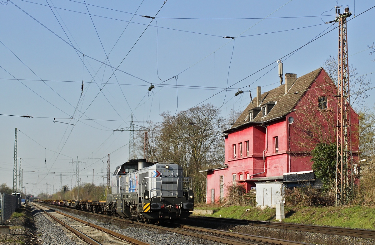 Dieselpower in Ratingen-Lintorf: Am 05.04.2023 fährt die Vossloh DE 18 DE 508 der RheinCargo (92 80 4185 033-2 D-RHC) am alten Bahnhofsgebäude vorbei nach Süden