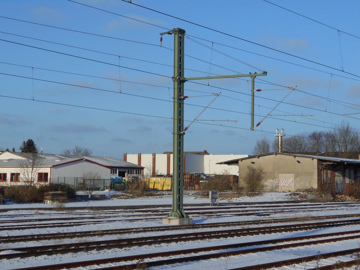 Dieser Fahrleitungsmast,mit zwei Auslegern,überspannt zwei Gütergleise in Bergen/Rügen.Aufnahme vom 24.Januar 2019.