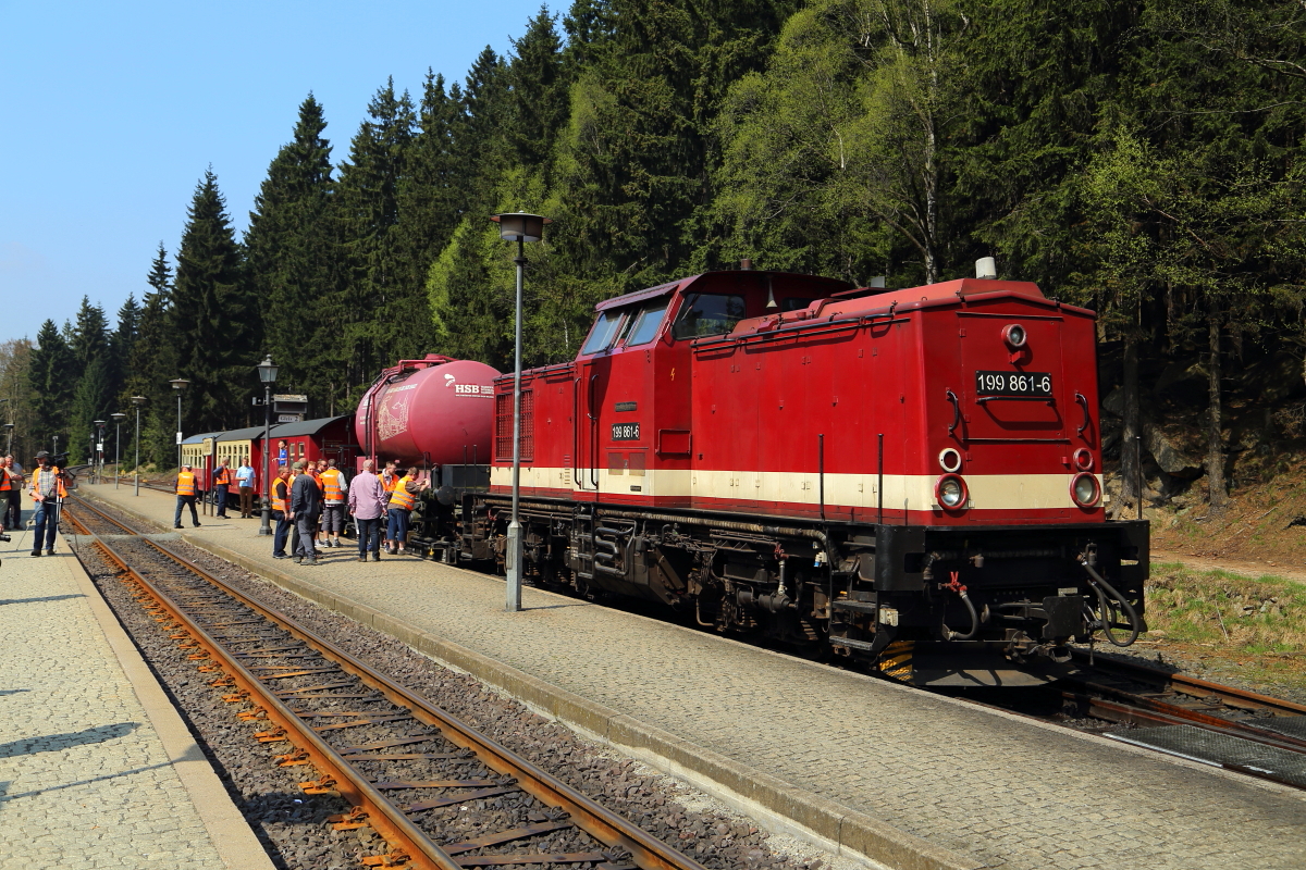 Dieses Bild zeigt 199 861 mit dem Sonder-GmP am 21.04.2018 kurz nach der Einfahrt in den Bahnhof Schierke. Da hier die Kreuzung mit P 8920 abgewartet werden muß und dies etwas länger dauert, nutzen die Fotografen die Zeit für ein paar Detailaufnahmen. 
An dieser Stelle vielleicht mal ein paar Worte zu den orangen Warnwesten: Die Teilnehmer der Sonderfahrt bekamen diese vor Fahrtantritt von der HSB GmbH ausgehändigt, mit der Auflage, sie während der gesamten Veranstaltung aus Sicherheitsgründen zu tragen, da im Rahmen der Fotohalte auch gelegentlich legal Gleise überschritten werden, was unter strenger Aufsicht von Bahnpersonal und Reiseleitung geschieht und außerhalb der Veranstaltungen natürlich nicht gestattet ist!!!. Disziplinverstöße werden hierbei nicht geduldet! Desweiteren bekam man eine schriftliche Sicherheitsunterweisung, welche unterschrieben zurückgegeben werden mußte. Auch wenn die Westen für uns Fotografen nicht gerade bildförderlich waren, so herrschte dennoch größtenteils Einsehen. Denn auch hier gilt:  Safety first!  und das ist auch gut so!