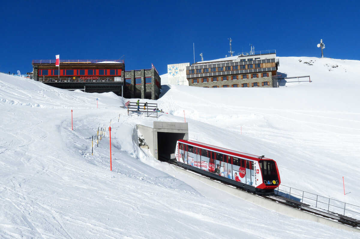 Direkter Blick von der Skipiste auf die Parsennbahn: Fahrzeug Nr. 4 fährt sogleich in den Tunnel ein und erreicht nachher die unterirdische Bergstation Weissfluhjoch (2662 müM). Davos, 09.02.20218