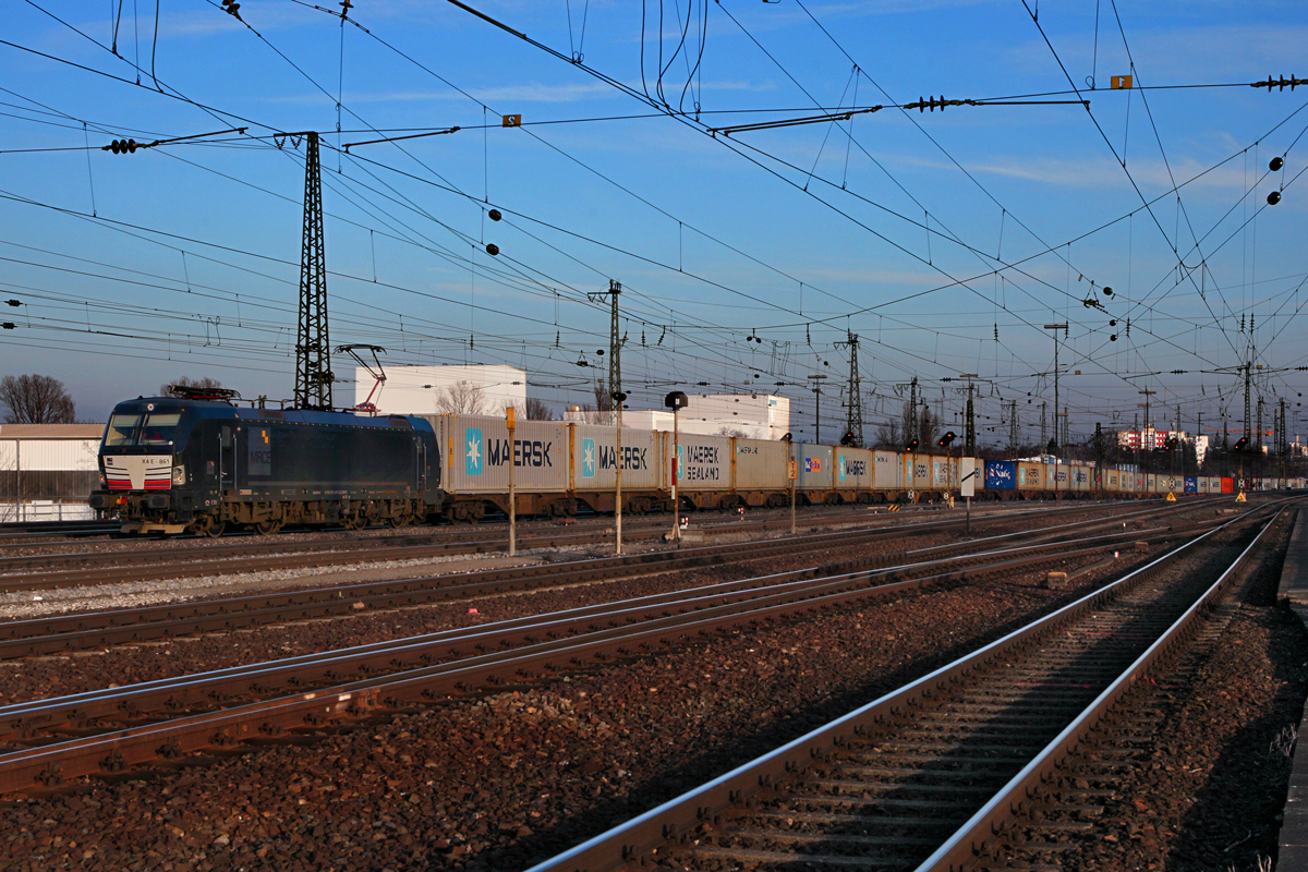 Dispolok der MRCE X4E 861 verlässt abends mit einem sehr langen Containerzug die Stadt Nürnberg Richtung  Rbf Kornwestheim.Bild vom 14.2.2015