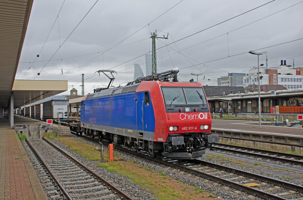 Donnerstag den 20.04.2023 um 10:35 Uhr in Basel Bad Bf. Die 91 85 4482 011-4 CH-SBBC fährt mit einem Güterzug durch den Badischen Personenbahnhof in Richtung Norden. Auf der blauen Fläche ist noch schwach die grosse Anschrift „Cargo“ zu lesen auch die kleine Anschrift „SBB CFF FFS Cargo“ im unteren rechten Bereich ist noch gut ersichtlich. Heute ist an der Front „ChemOil“ das grosse Thema. Hersteller: Bombardier Transportation GmbH, Kassel. Fabriknummer: 33525. Baujahr: 2002. Bombardier Transportation war ein weltweit tätiger Hersteller von Schienenfahrzeugen mit Geschäftssitz in Berlin. Bis 2021 bildete das Unternehmen einen Teilkonzern des kanadischen Unternehmens Bombardier. Es wurde im Januar 2021 vom französischen Konkurrenten Alstom übernommen. Es handelt sich um eine TRAXX F140 AC1. Die Varianten TRAXX F140 AC1 / AC2 / MS sind vierachsige elektrische Lokomotiven, die mit zwei oder drei Spannungen betrieben werden können. Diese Lokomotive erfüllt alle erforderlichen Vorgaben für einen grenzüberschreitenden Güterschwerlastverkehr auf der Schiene. Die Frontanschrift „ChemOil“ bezieht sich auf die ChemOil AG. Sie wurde 1999 gegründet und ist eine Tochterunternehmung von SBB Cargo. Das Unternehmen erbringt qualitativ hochwertige Dienstleistungen für Kunden aus der Chemie- und Mineralöl-Branche. Wetter: Trüb und Regen.