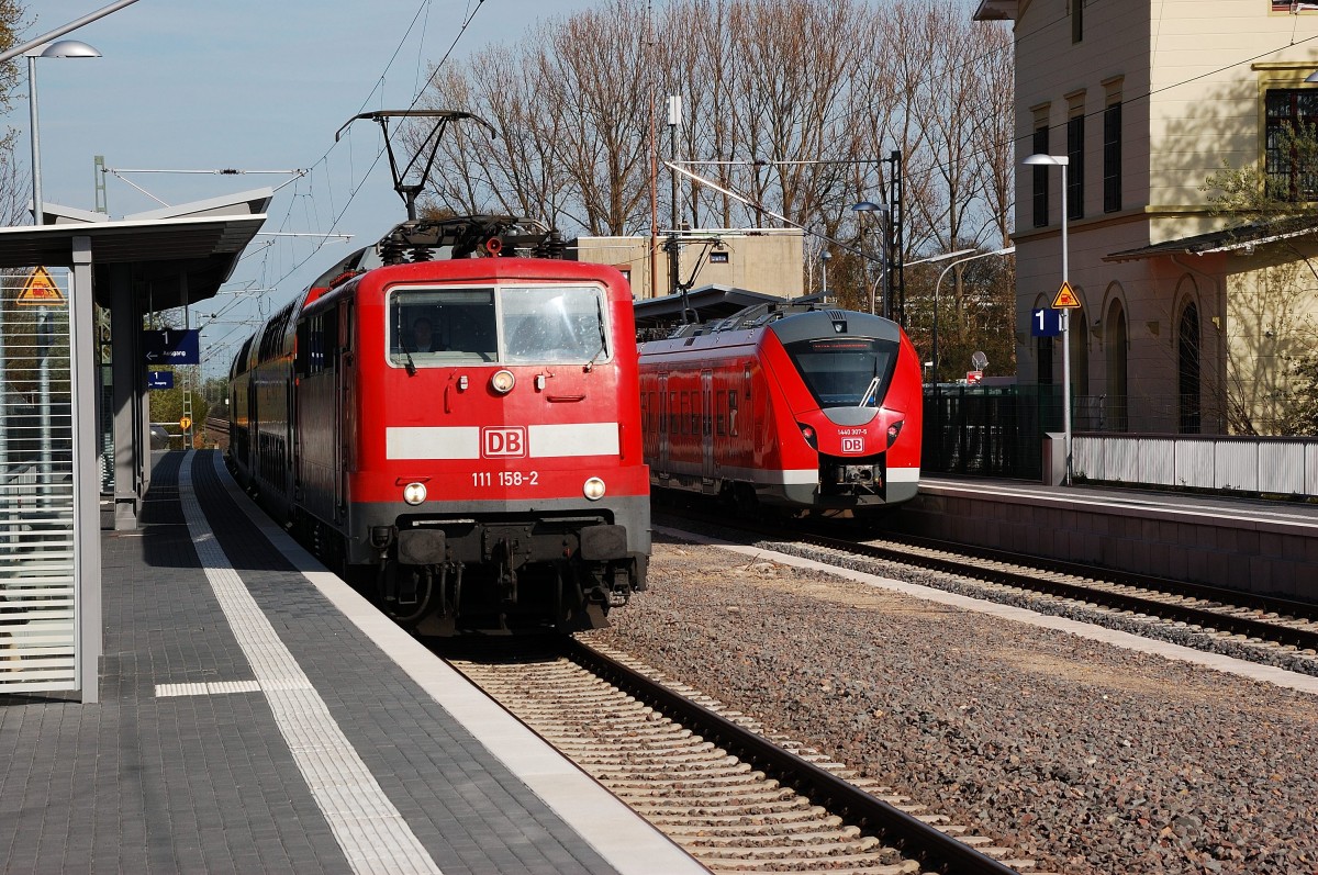 Doppelpack, links ein RE4 Dostockzug der von der 111 158-2 gezogen durch Kleinenbroich nach Aachen fahrend. Rechts verlässt eine Doppeleinheit Grinsekatzen alias 1440 324-0 vorne und 1440 307-5 als S5/S8 nach Wuppertal Barmen. 14.4.2015