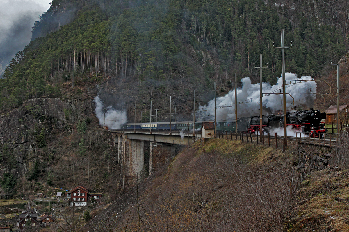 Doppeltraktion der beiden Dampfloks 01 202 und 01 1066-7 fahren mit der Schublok Ae 6/6 11407 mit einem Sonderzug aus Wohlen kommend nach Locarno über die Kerstelenbachbrücke in Amsteg den Gotthard hoch.Bild vom 5.3.2015