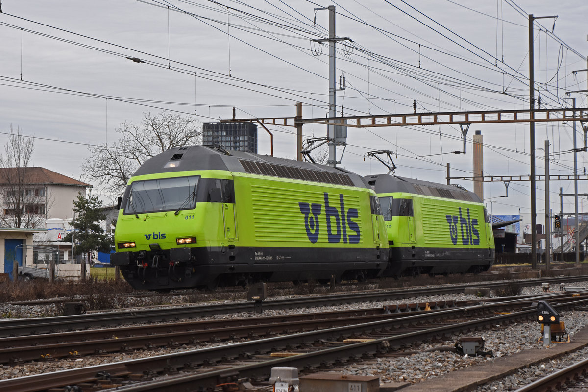 Doppeltraktion, mit den BLS Loks 465 011-5 und 465 012-3, wird nach einem Rangiermanöver auf einem Abstellgleis beim Bahnhof Pratteln abgestellt. Die Aufnahme stammt vom 04.02.2021.