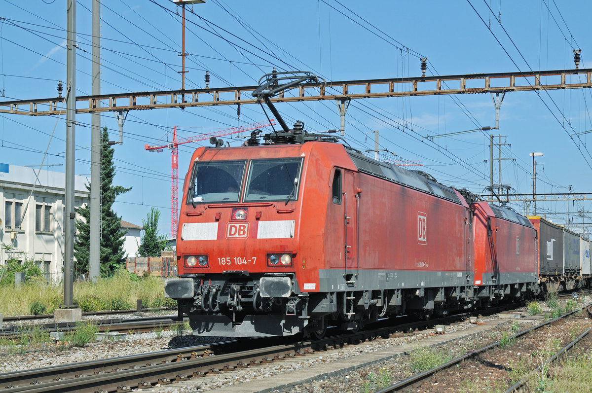 Doppeltraktion, mit den DB Loks 185 104-7 und 185 114-6, durchfahren den Bahnhof Pratteln. Das abzweigende Gleis führt auf eine Strasse und in ein Industriegebiet, von wo aus auch diese Aufnahme am 03.08.2016 entstand. 