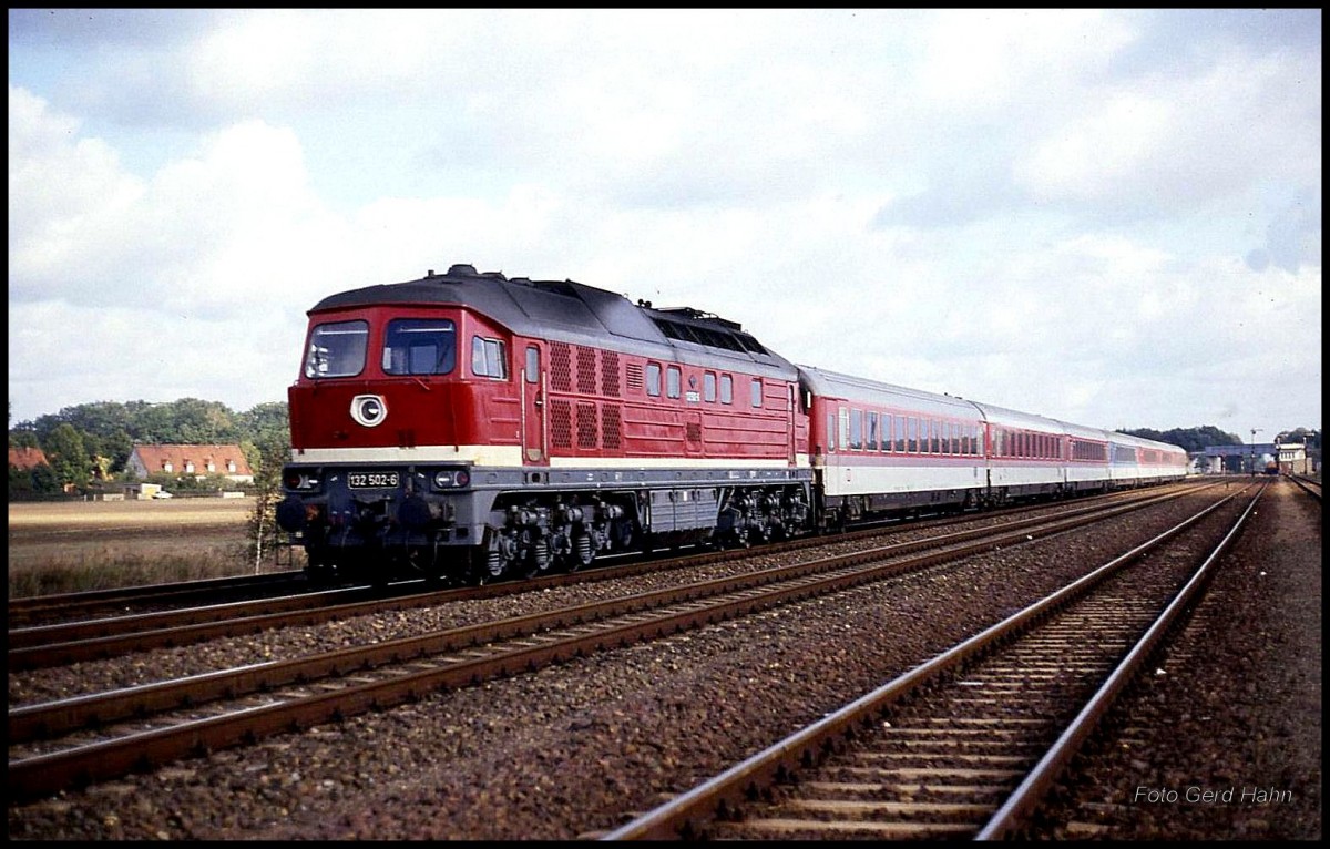 DR 132502 fährt mit IC 502  Havelland  aus Berlin in Richtung Magdeburg am 19.10.1991 um 12.57 Uhr durch den Bahnhof Güsen. - Im Hintergrund ist die Eisenbahnüberführung der Strecke nach Jerichow zu erkennen.