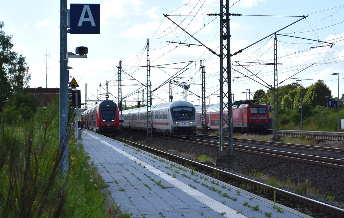 Drei auf einen Streich. Zwei RE1, eine nach Hamburg unterwegs mit einer BR 112 und eine in Richtung Hagenower Land, mit einer BR 182. Bei der Durchfahrt am Bahnhof Büchen, ein IC in Richtung Schwerin. 26.06.2017