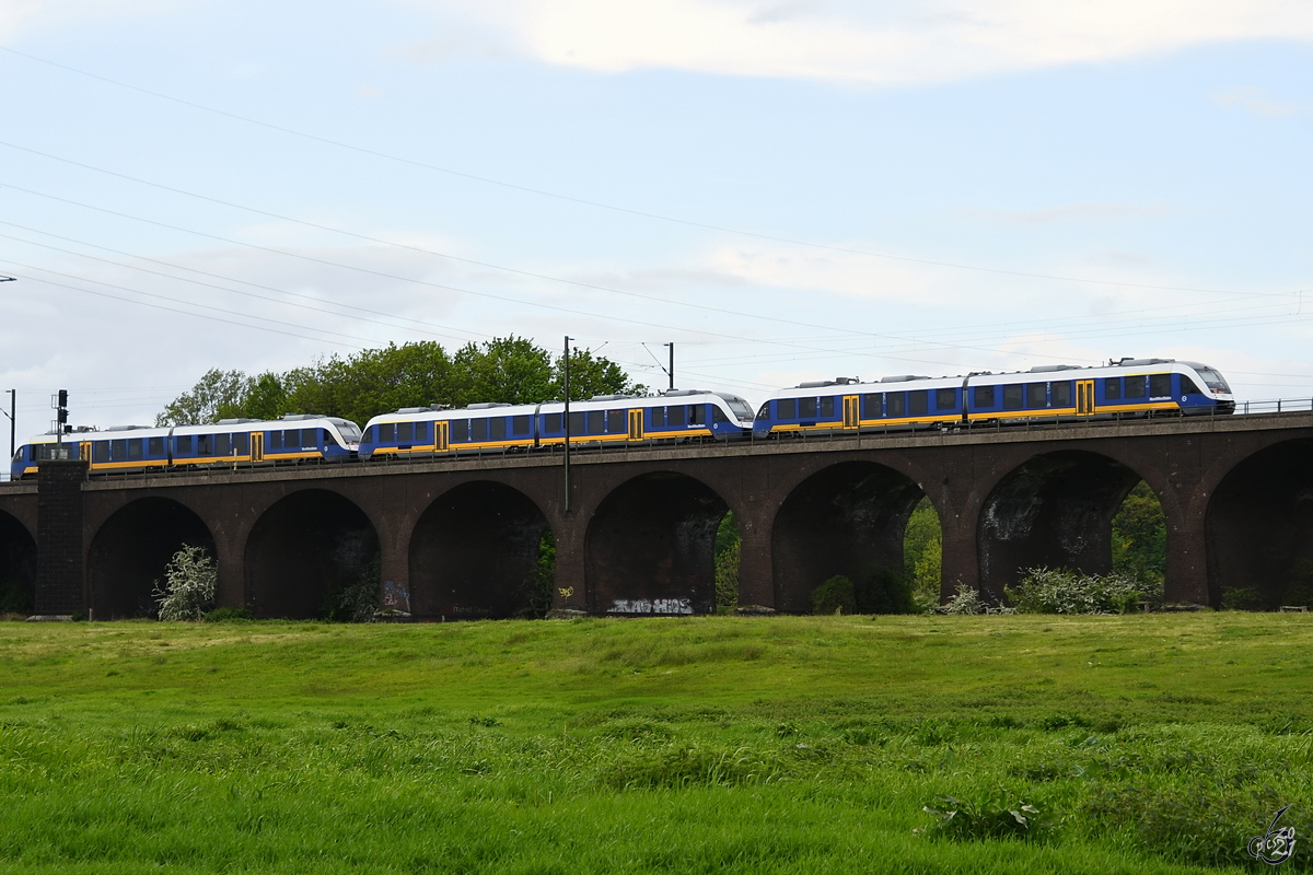 Drei gekoppelte Dieseltriebzüge der NordWestBahn befahren Anfang Mai 2021 die Hochfelder Eisenbahnbrücke in Duisburg.