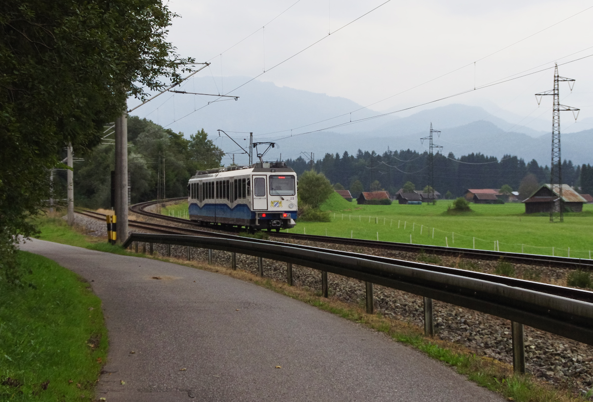 Drei Kilometer verlaufen die Zugspitzbahn und die Außerfernbahn vom Bahnhof Garmisch-Partenkirchen parallel nebeneinander. Triebwagen 15 der Zugspitzbahn wird gleich nach Oben steigen und die Außerfernbahn  überfahren . 16.09.2016 bei Rießersee