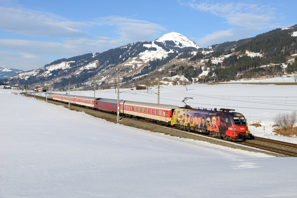 DRV 13817 nach Zell am See erfreute dann aber mit einem Werbe-Taurus: Am 21. Februar 2015 war die ÖAMTC-Lok 1116.153 zur Beförderung des Turnuszuges ab Wörgl eingeteilt. An der bekannten Fotostelle bei Brixen im Thale mit Blick auf die hohe Salve war der Zug trotz herannahender Schlechtwetterfront noch  sichere Beute .