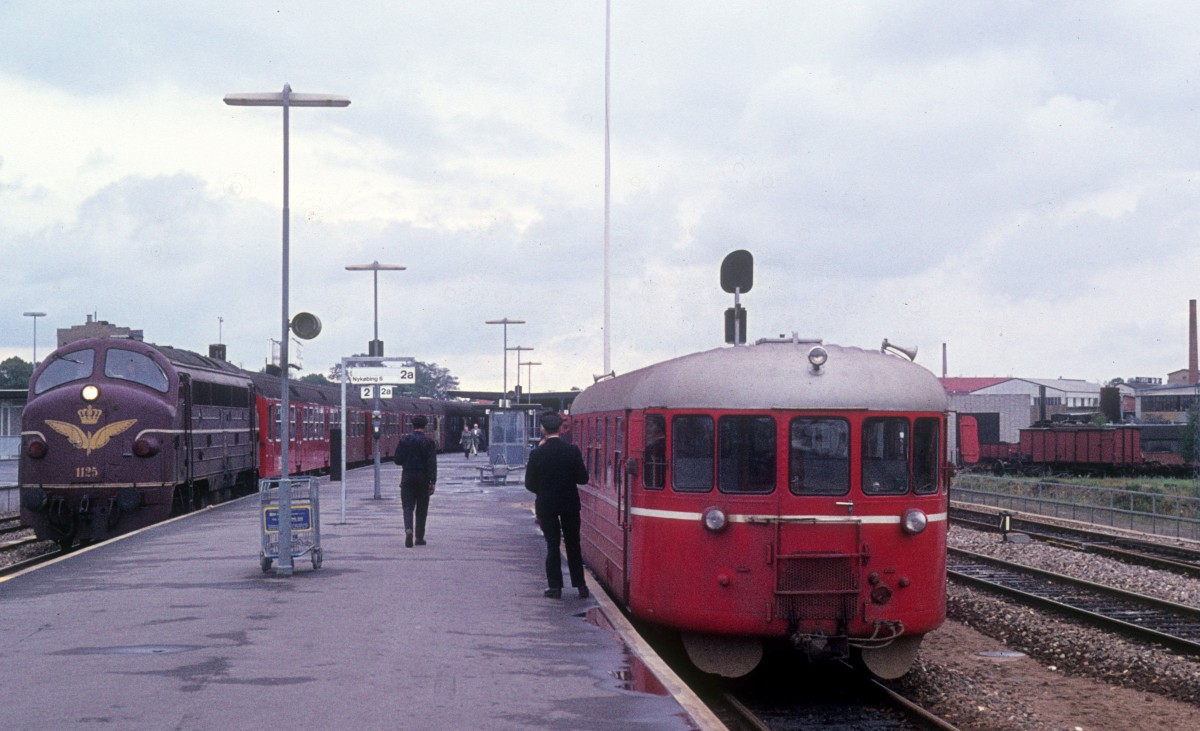 DSB-Bahnhof Holbæk am 25. Juli 1974: DSB My 1125 mit einem Regionalzug am Gleis 2 / OHJ (Odsherreds Jernbane) Schienenbus S xx (Hilding Carlsson, Umeå, Schweden 1951) am Gleis 2a.