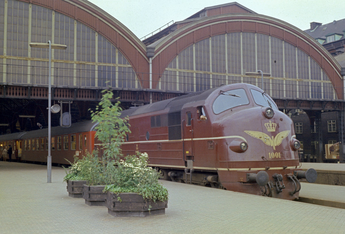 DSB København H: Am 25. Mai 1974 hält die dieselelektrische Lok MX 1001 (Nohab 1960) mit dem Lyntog (:  Blitzzug  = FD-Zug)  Østjyden  nach Ålborg im Kopenhagener Hauptbahnhof. - An diesem Tag fuhren die letzten von Loks gezogenen FD-Züge, ab dem folgenden Tag fuhren die ersten dänischen IC-Züge. - Scan eines Farbnegativs. Film: Alfochrome-Ringfoto (= Sakuracolor R-100?). Kamera: Kodak Retina Automatic II.  