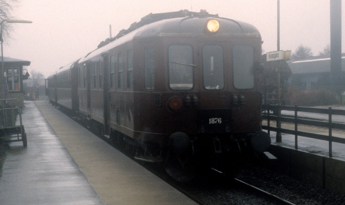 DSB  Lille Nord  (:  kleine Nordbahn , d.h. die Bahnstrecke zwischen Hillerød und Helsingør über Fredensborg, Kvistgård und Snekkersten) Mo 1876 + Cl + Bhs Bahnhof Kvistgård am 27. Dezember 1983. - Heute fahren hier moderne Triebzüge des Typs LINT 41 des Bahnunternehmens Lokalbanen.