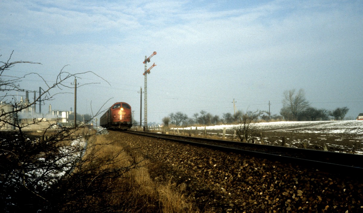 DSB Mx 1015 mit einem Regionalzug bei der Ausfahrt vom Bahnhof Lille Skensved. Der Zug fährt in Richtung Køge. Datum: 26. Februar 1983.