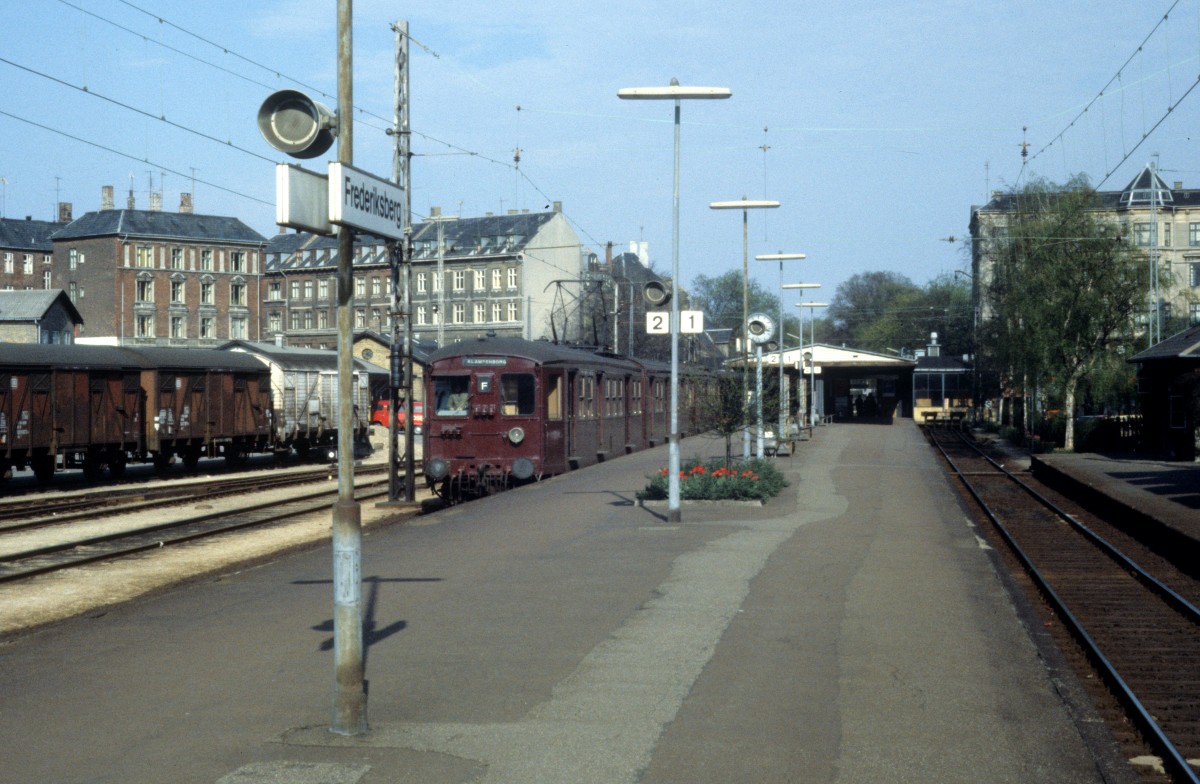 DSB S-Bahn Kopenhagen: Ein S-Bahnzug der ersten Generation hlt im S-Bf Frederiksberg im Juni 1978. - Es gab S-Bahnbetrieb zwischen Vanlse und Frederiksberg in den Jahren 1934 - 1998 und Gterverkehr bis 1996. Seit 2003 fhrt auf dieser Strecke die Zge der Kopenhagener Metro. Auf dem Gebiet des ehemaligen Gterbahnhofs und S-Bahnhofs befindet sich heute ein Einkaufszentrum ( Frederiksberg-Centret ). Die Haltestelle der Metro ist untererirdisch.