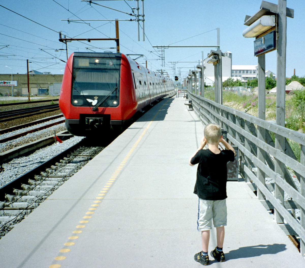 DSB S-Bahn Kopenhagen Linie F: Ein ankommender Zug, der aus Wagen der vierten Generation (Baujahre 1995 - 2005) besteht, erreicht am 1. Juli 2006 den provisorischen Endbahnhof Ny Ellebjerg. - Die Ankunft des Zuges wurde auch von einem jungen Bahnfotografen, meinem damals 7jährigen Sohn Stefan, verewigt. - Scan eines Farbnegativs. Film: Agfa XRG 200-N. Kamera: Leica C2.