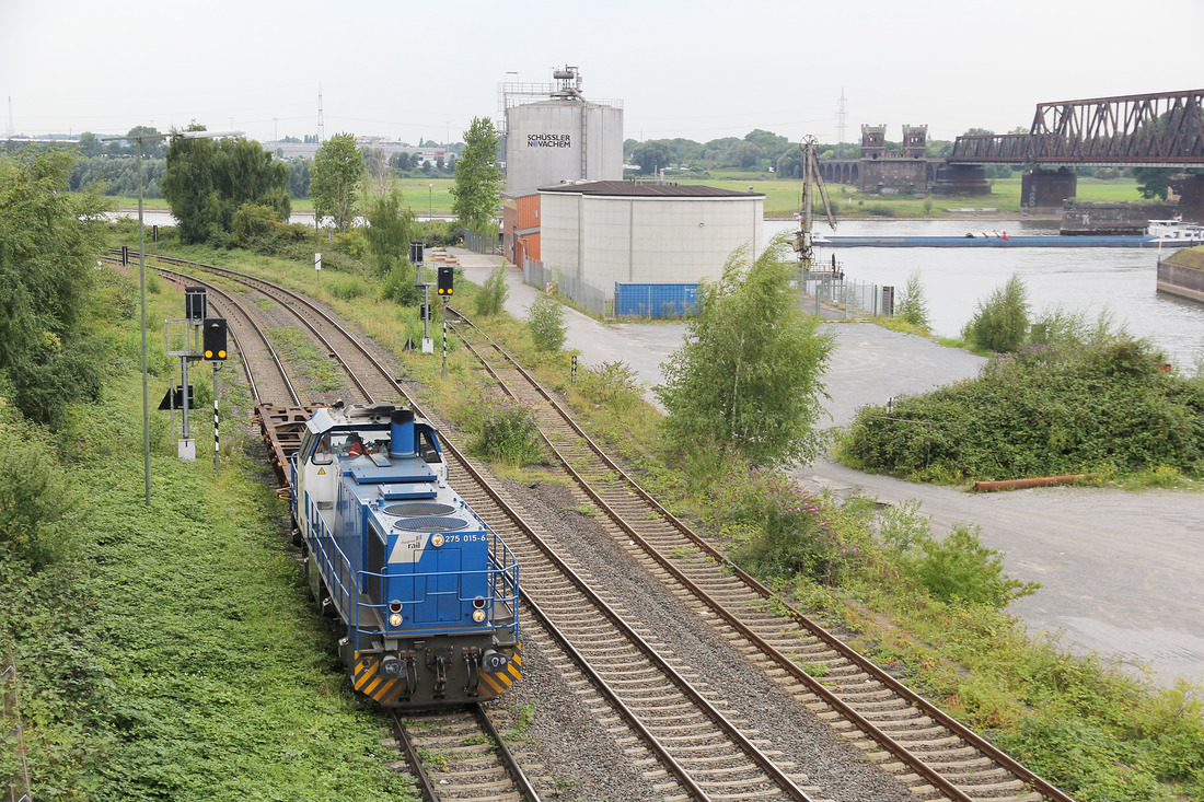 Duisport Rail 275 015 kommt mit einem leeren Containertragwagen vom Logport II.
Aufgenommen im Bereich des Güterbahnhofs Duisburg-Hochfeld Süd am 8. August 2017.
