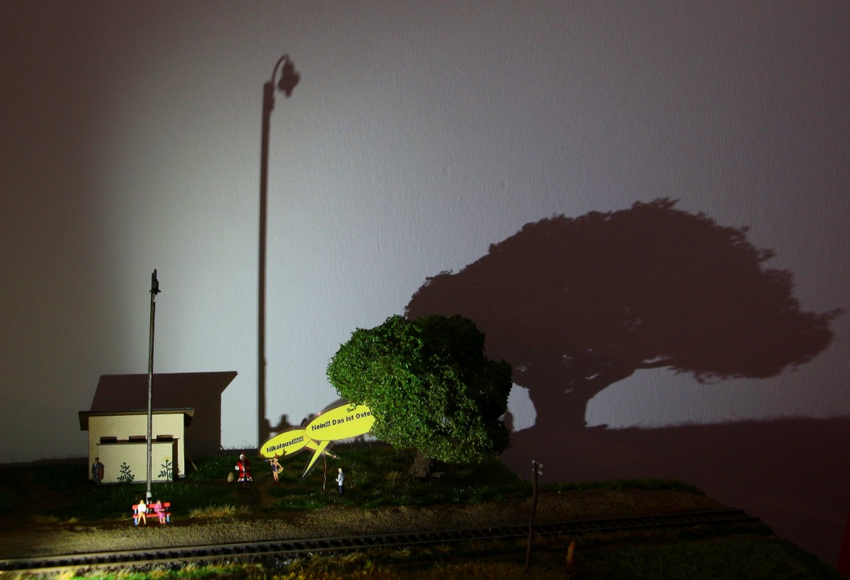 Dunkle Schatten ziehen auf über dem Land wo die Hasen und Weihnachtsmänner schön wohnen:-) Haltestelle Wies Markt. Anno dazumal als es noch Wartehäuschen und WC gab streiten sich Enkel und Großvater über Osterhasi und Nikolausi. Im Juni wird dann die Sulmtalbahn vorbei rattern und die Szene nur kurz stören. 23.03.2014 