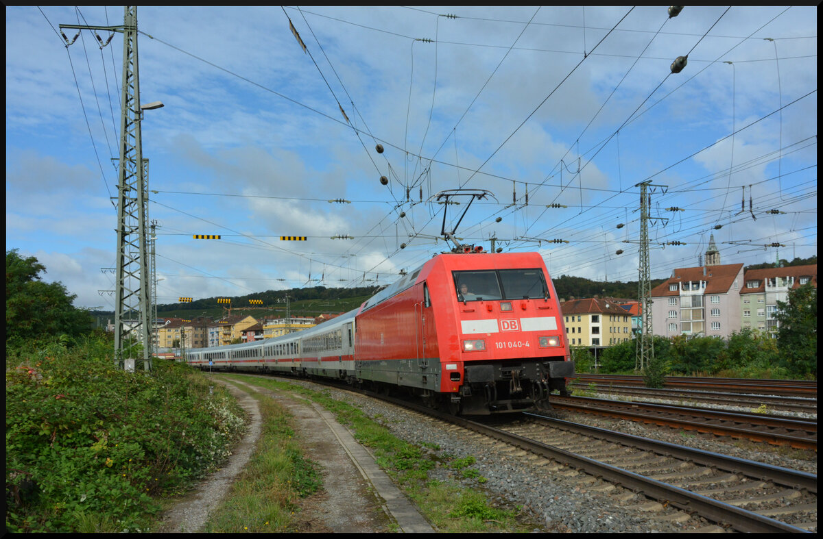 Dunkle Wolken über dem IC Königssee: Der Intercity 2083 „Königssee“ verkehrte am 28.09.2024 nicht von Hamburg-Altona, sondern erst ab Würzburg nach Berchtesgaden. Am Vortag war der Gegenzug IC 2082 wegen eines technischen Defekts in Augsburg liegengeblieben, s. d. der Wagenpark dort über Nacht verbleiben musste. Um den Umlauf wiederherzustellen, führte man deshalb am Vormittag des 28.09.2024 den Leerpark im Sandwich mit DB 101 057 „Europa“ und DB 101 040 (verkehrsrot) von Augsburg nach Würzburg. Pünktlich um 11:24 Uhr startete der Intercity „Königssee“, nun bei Sonnenschein und der führenden 101 040, zu seiner Reise nach Berchtesgaden.
