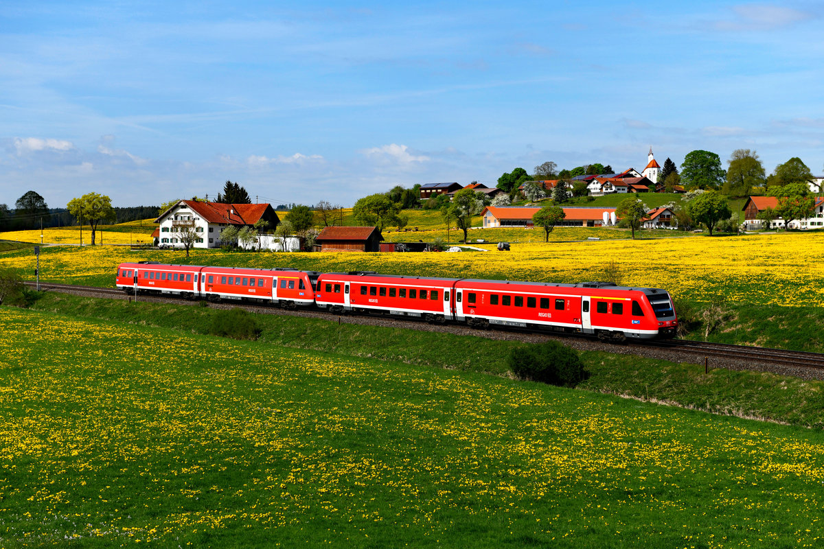 Durch die blühenden Löwenzahnwiesen des Ostallgäus eilten am 25. April 2018 die 612 080 und 088 als RE 3285 von Lindau nach Augsburg HBF. Das Gehöft links im Bild ist übrigens der Sommerhof. Es genießt eine gewisse mediale Präsenz, da dort in schlechten Witterungslagen gerne Radiomoderatoren auftauchen, wenn sie auf der Suche nach dem Sommer sind....