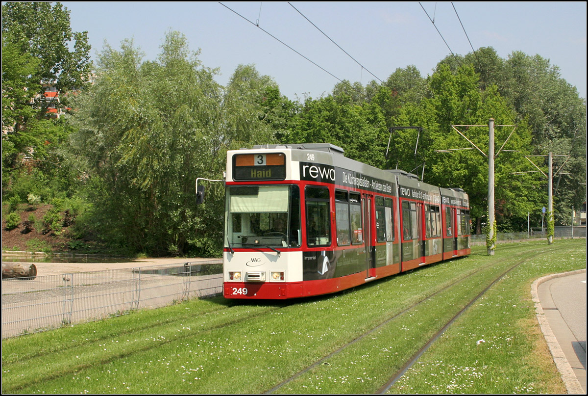 Durch Freiburg-Weingarten nach Haid -

Blick von der Haltestelle 'Bugginger Straße' nach Norden auf den Rasenbahnkörper in westlicher Seitenlage zur Straße 'Binzengrün' in Weingarten.

Aufgrund der Erweiterung des Streckennetzes nach Haid wurden auch neue Straßenbahnwagen nötig. Bei DÜEWAG wurden dann die 26 Wagen vom Typ GT8Z gebaut, mit einem Niederfluranteil von 48 % und Drehgestellen. Das Z steht für Zweirichtungsfahrzeuge, da es nicht überall Wendeschleifen gibt. Der GT8Z ersetzte dann auch die letzten GT4-Wagen in Freiburg.

11.05.2006 (M)