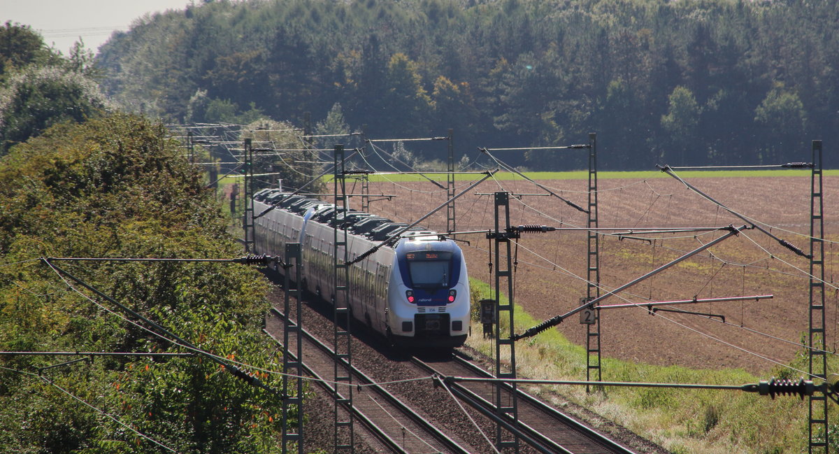 Durch den Wald aus Masten und Bäumen fahren zwei blau-weiße Hamsterbacken - hinten zu sehen 442 356 - von National Express als RE 7 (Krefeld - Rheine) Köln-Weiler entgegen.
Köln Worringen, 23. August 2016