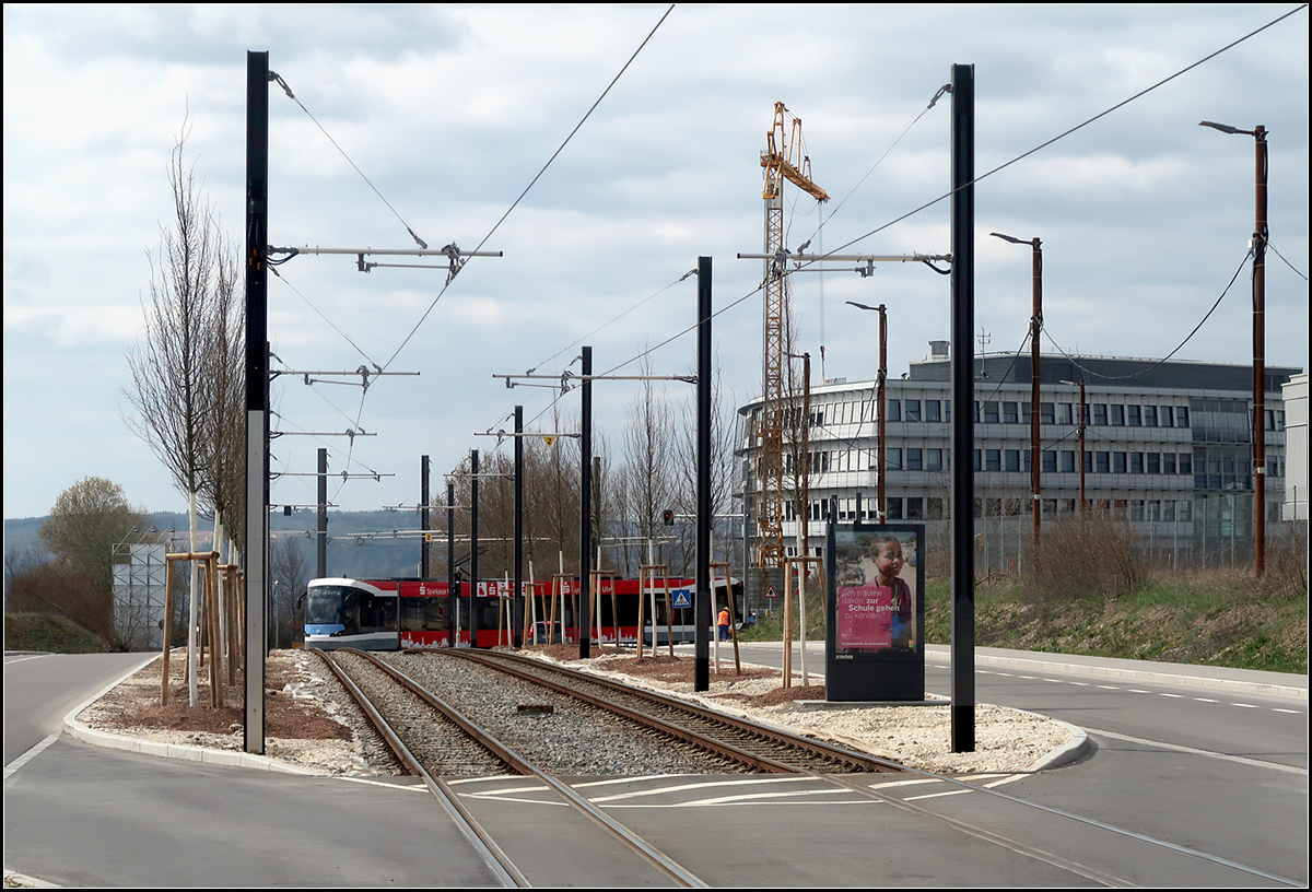 Durch die Wissenschaftsstadt -

... auf dem Ulmer Eselsberg hat die Straßenbahnlinie 2 einen durchgehenden eigenen Bahnkörper in Straßenmitte erhalten. Der Schotterbahnkörper soll später noch Rasen erhalten. Wenn die Bäume rechts und links der Schienen groß geworden sind fallen die Oberleitungsmasten kaum noch auf. Der Avenio M kommt von der Endhaltestelle Science Park II und wird bald die Haltestelle Hochschule erreichen.

Mit über 600 Meter über dem Meerspiegel ist die Strecke in der Wissenschaftsstadt wohl die am höchsten gelegene Straßenbahnstrecke in Deutschland.

28.03.2019 (M)