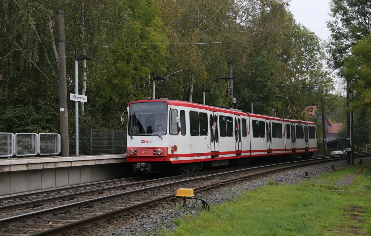 Durch eine wunderschöne Herbstlandschaft verkehrt derzeit die U-Bahn Linie 47 in den Außenbereichen von Dortmund. Zur echten U-Bahn wird sie nur im Stadtkern Bereich. Eine Besonderheit dieser Linie: Zwischen Obernette und der Stadtmitte überquert diese Strecke in gleicher Höhe im neunzig Grad Winkel eine zweigleisige elektrifizierte Eisenbahnstrecke! Eine echte Eisenbahnkreuzung!
Das Foto zeigt den Triebzug 361 der DSW 21 auf der Linie U 47 am 18.10.2020 bei der Einfahrt in Obernette auf dem Weg zum Endhaltepunkt Westerfilde. 
