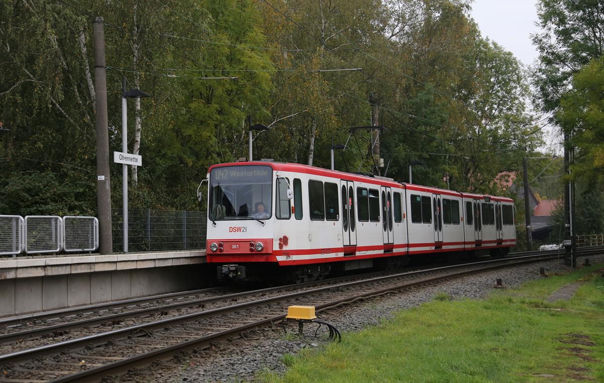 Durch eine wunderschöne Herbstlandschaft verkehrt derzeit die U-Bahn Linie 47 in den Außenbereichen von Dortmund. Zur echten U-Bahn wird sie nur im Stadtkern Bereich. Eine Besonderheit dieser Linie: Zwischen Obernette und der Stadtmitte überquert diese Strecke in gleicher Höhe im neunzig Grad Winkel eine zweigleisige elektrifizierte Eisenbahnstrecke! Eine echte Eisenbahnkreuzung!
Das Foto zeigt den Triebzug 361 der DSW 21 auf der Linie U 47 am 18.10.2020 bei der Einfahrt in Obernette auf dem Weg zum Endhaltepunkt Westerfilde. 