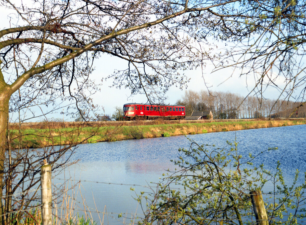 Durchblick auf NS 34 als Zug 8463 von Almelo nach Mariënberg bei Vriezenveen am 25.04.1985. Scanbild 93894, Kodak VericolorIII.