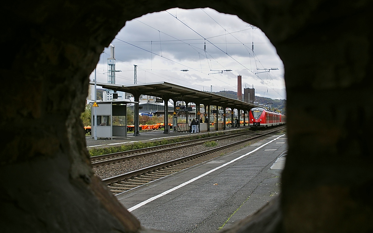 Durchblick aus dem Unterstand auf dem Bad Hönninger Hausbahnsteig auf den auf Gleis 2 einfahrenden 1440 875 (08.11.2023)