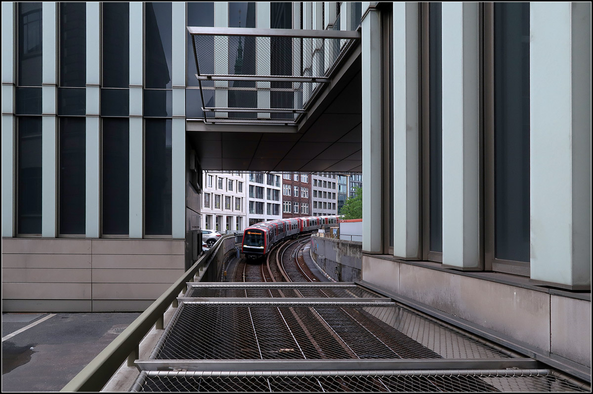 Durchblick -

Blick unter einem Neubau hindurch auf einen U-Bahnzug der Hamburger Linie U3, der von der Station Rödingsmarkt hinunter zur Haltestelle Rathaus rollt.

15.08.2018 (M)