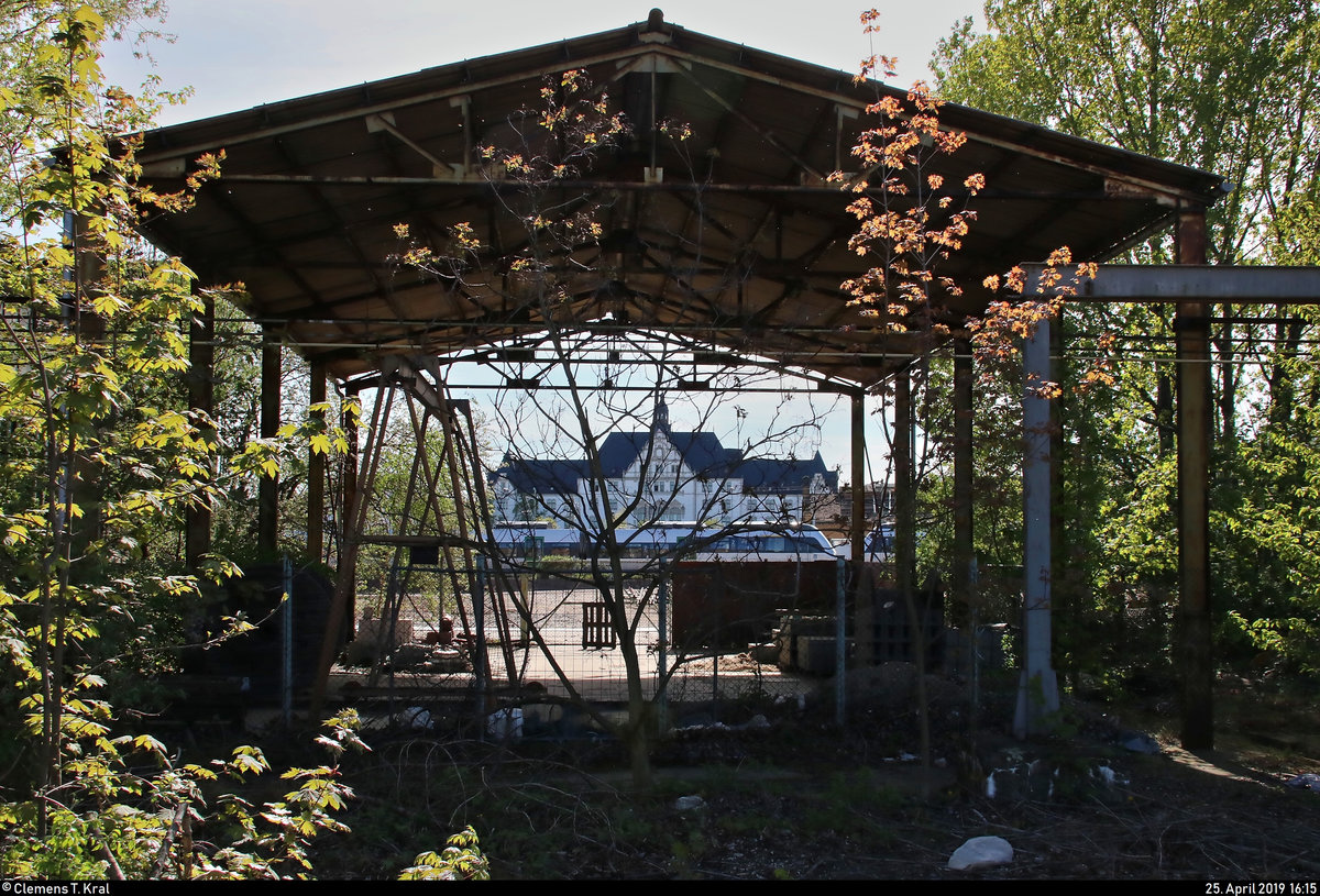 Durchblick vom ehemaligen Reichsbahnausbesserungswerk (RAW) in der Karl-von-Thielen-Straße (Gebiet der DR) auf das ehemalige Hauptgebäude der Reichsbahndirektion (Rbd) Halle (Saale) mit einer Doppeltraktion von 1442 (Bombardier Talent 2) der S-Bahn Mitteldeutschland (DB Regio Südost) als S 37525 (S5X) nach Zwickau(Sachs)Hbf, die ihren Startbahnhof Halle(Saale)Hbf auf Gleis 13 verlassen.
[25.4.2019 | 16:15 Uhr]